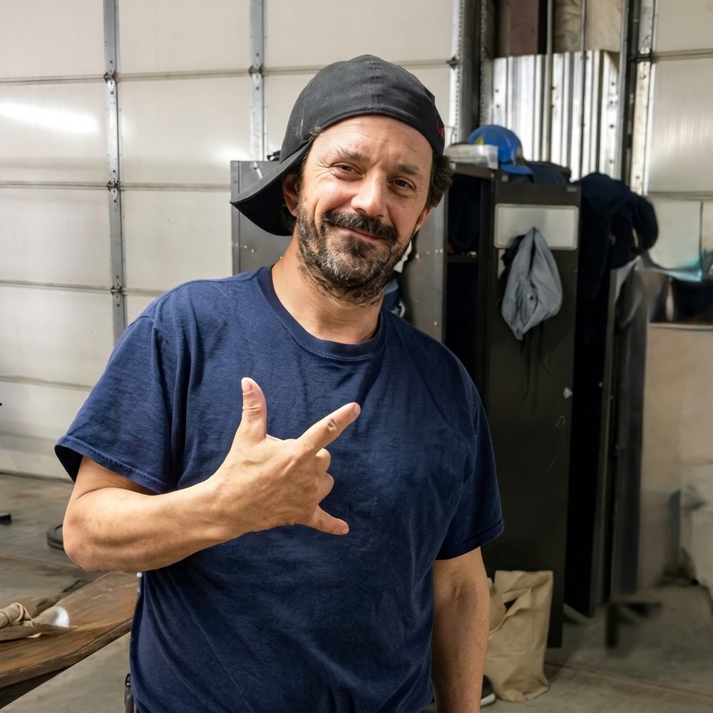 Guy Couture, freshly washed, grinning in a backwards cap and throwing a shaka